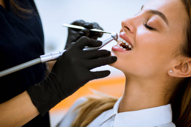 Close-up of female with open mouth during oral checkup at the dentist office